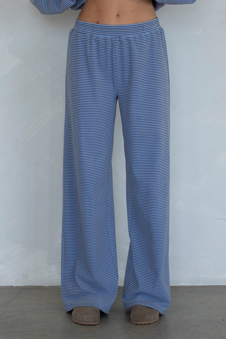 Blue striped pants worn by a person against a white background