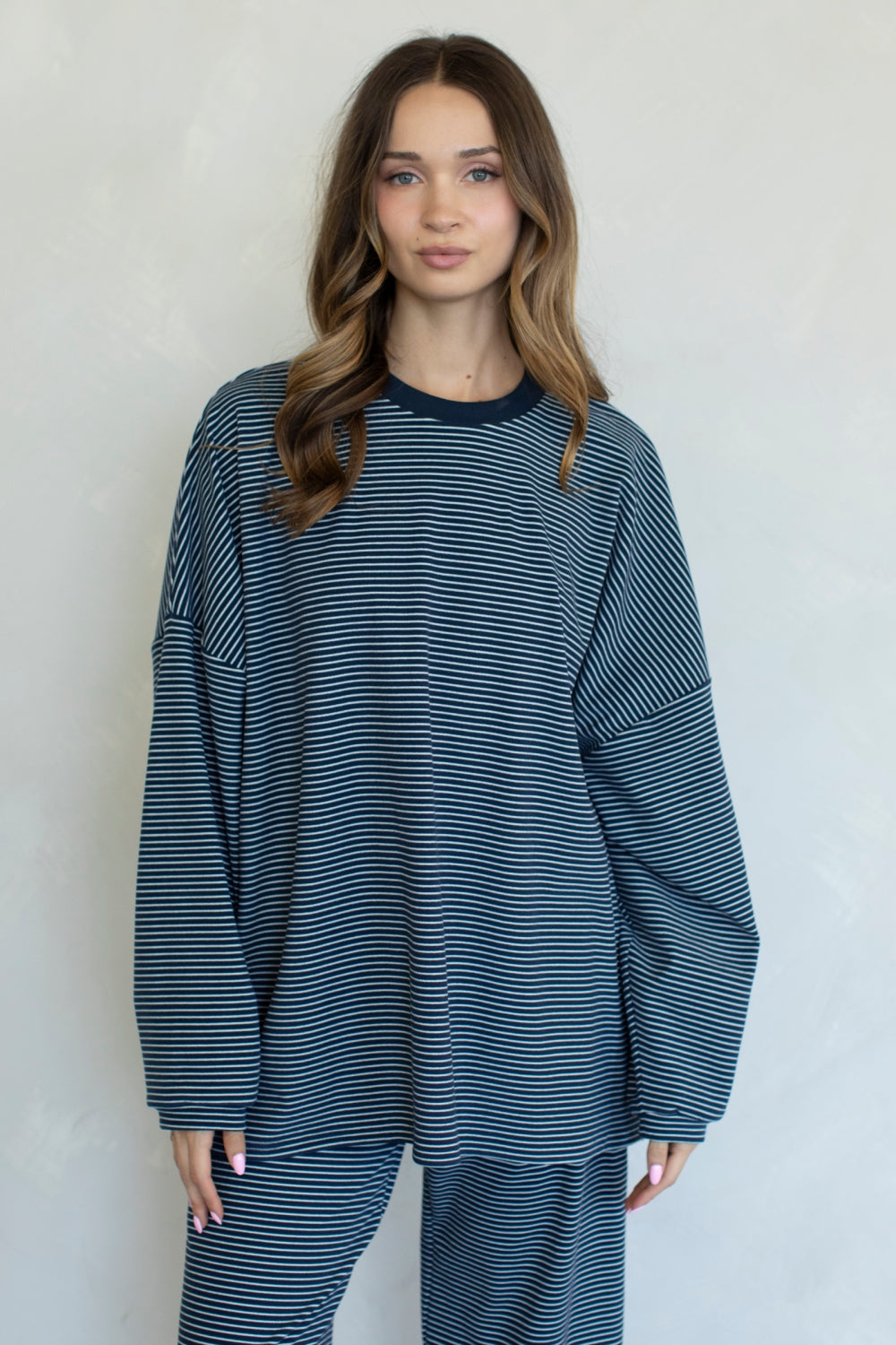 Woman wearing a blue and white striped outfit against a plain background