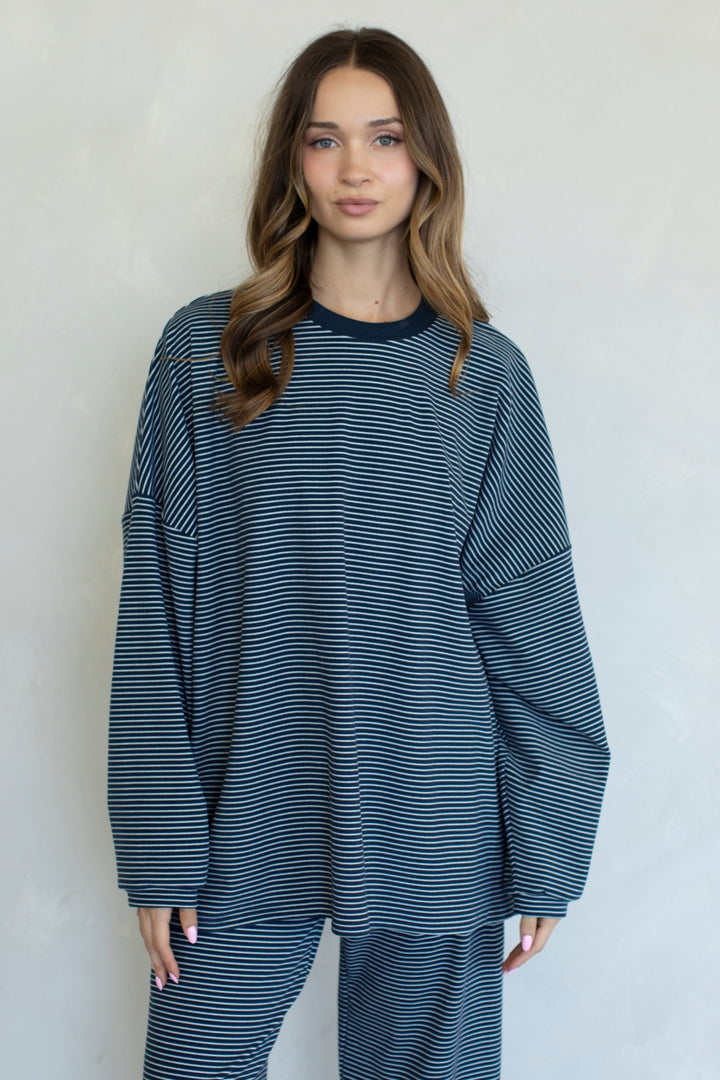 Woman wearing a blue and white striped outfit against a plain background