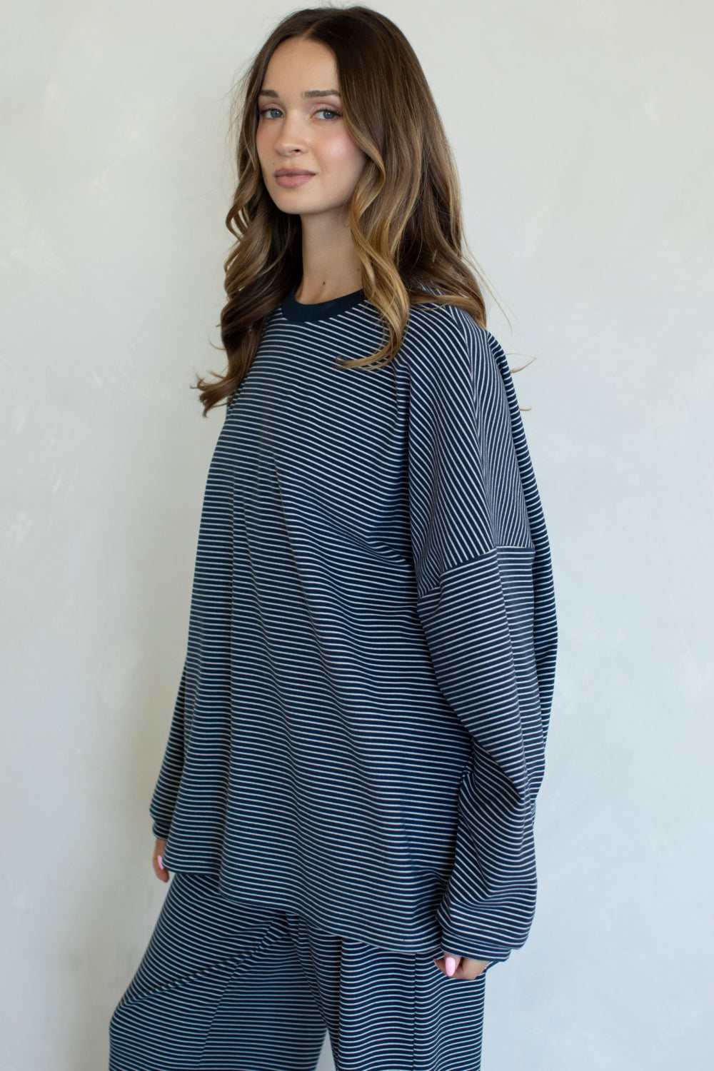 Woman wearing a blue and white striped outfit against a plain background