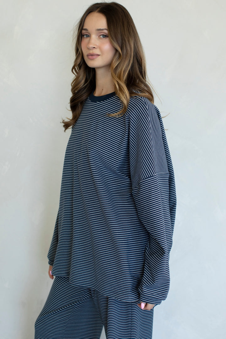 Woman wearing a blue and white striped outfit against a plain background