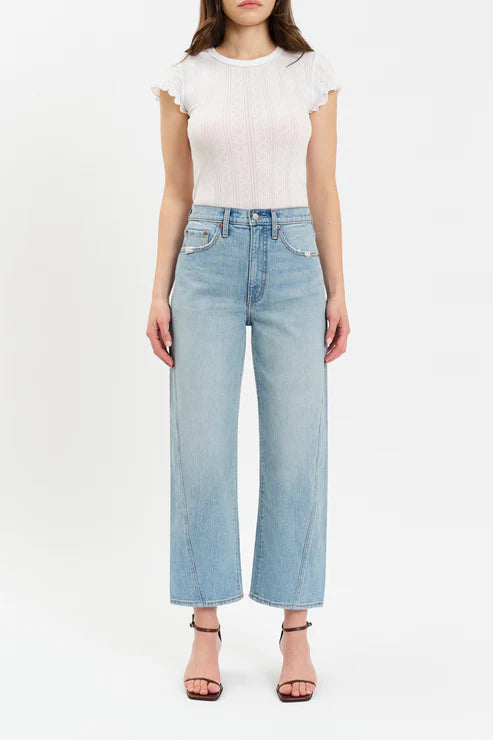Person wearing a white top and light blue jeans on a white background