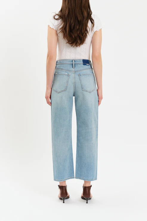 Person wearing light blue jeans on a white background