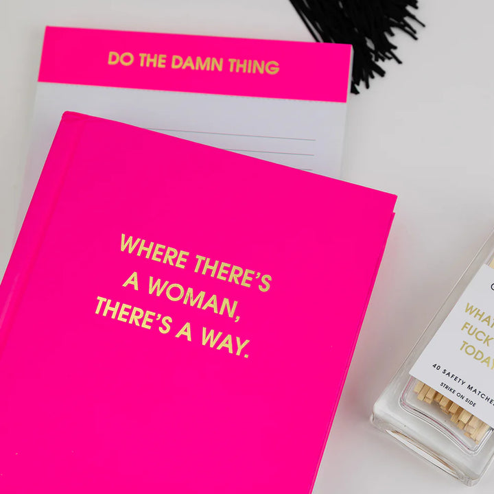 A bright pink hardcover book or journal with gold foil text reading &