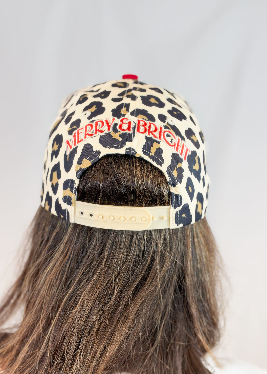 Woman shown from back wearing leopard print trucker hat and &