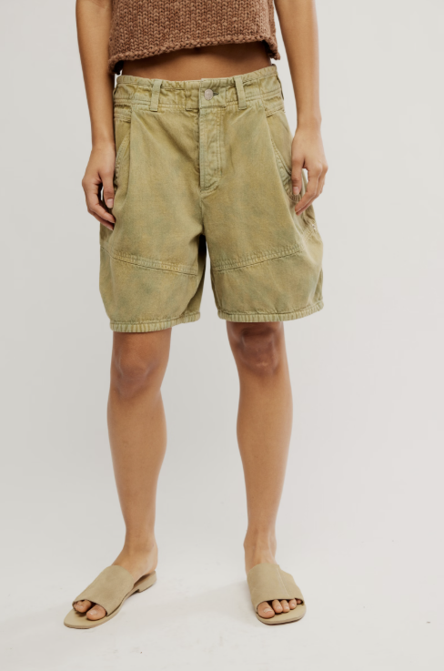 Person wearing light green shorts on a plain background