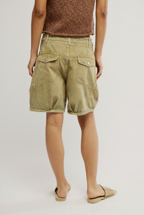 Person wearing green shorts on a plain background