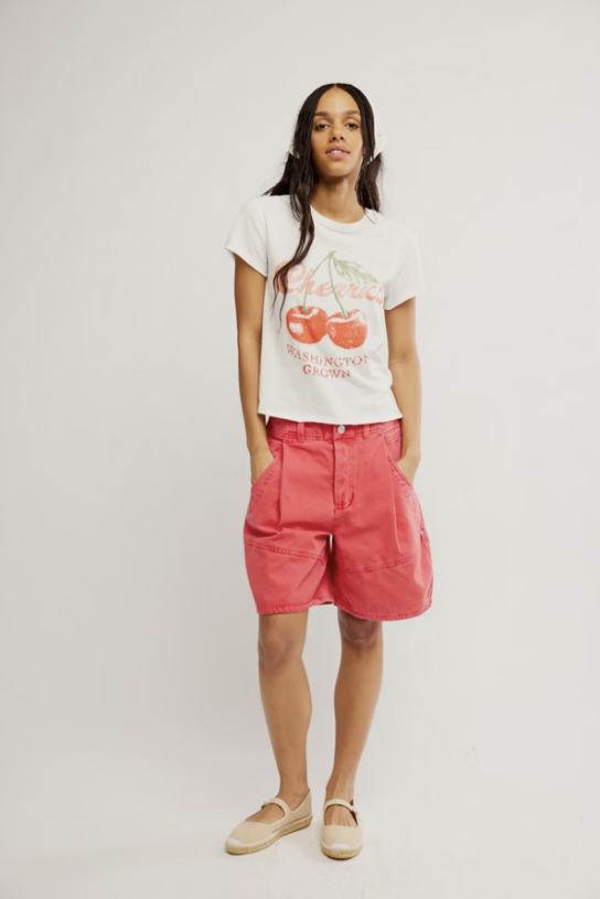 woman wearing red shorts and graphic tee on white background