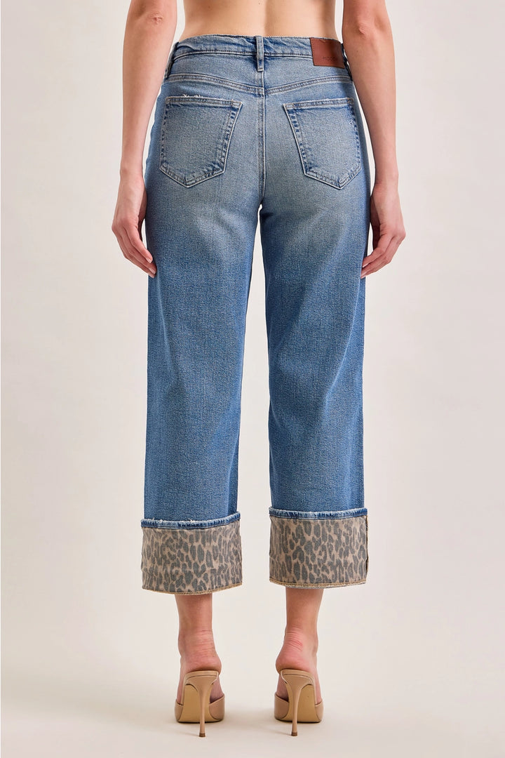 Back of denim pants with leopard cuffs on plain background