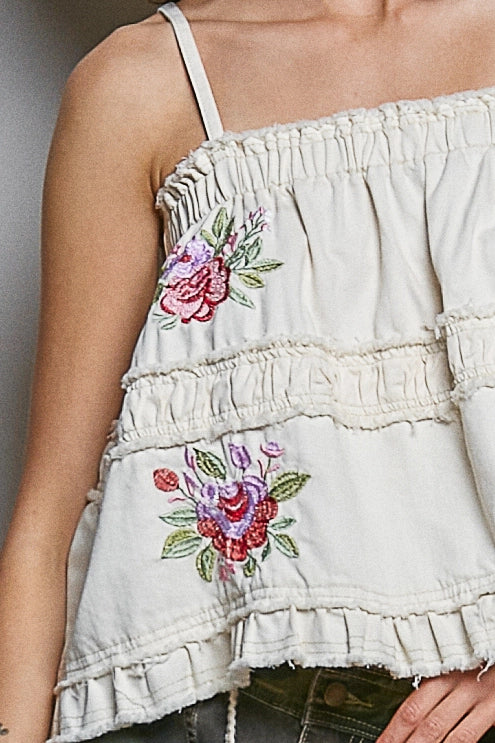 Close up of embroidered tank on plain background