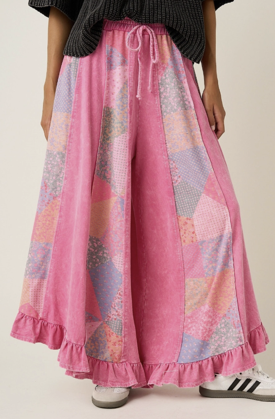 Woman wearing pink quilted patchwork palazzo pants on beige background