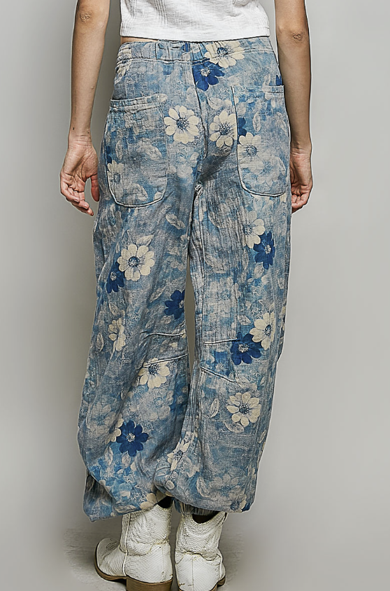 Person wearing blue floral-patterned pants on a plain background