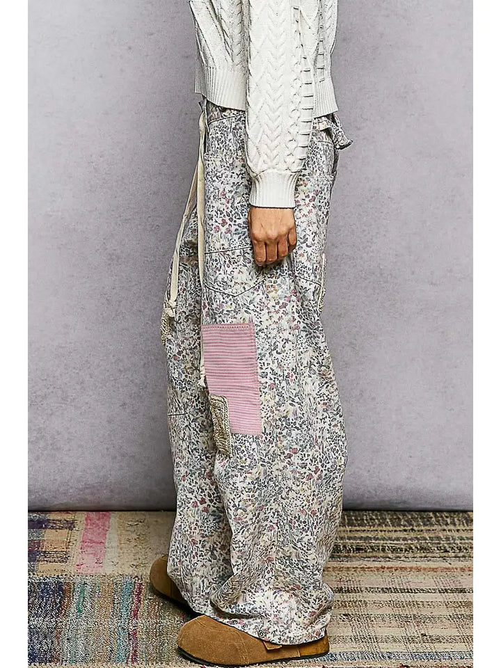 Person wearing a white sweater and patterned pants on a gray background