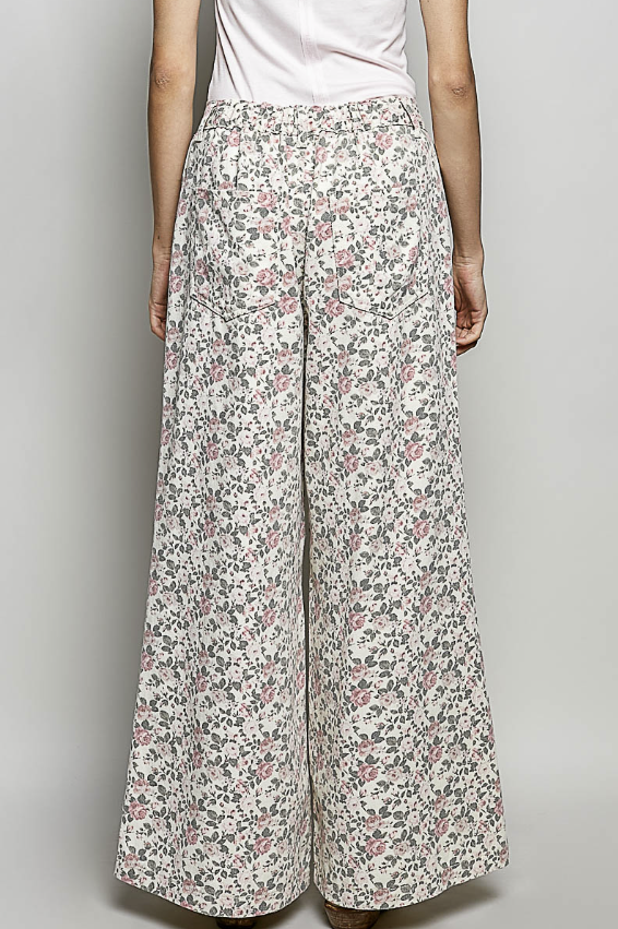 Floral patterned pants worn by a person on a plain background