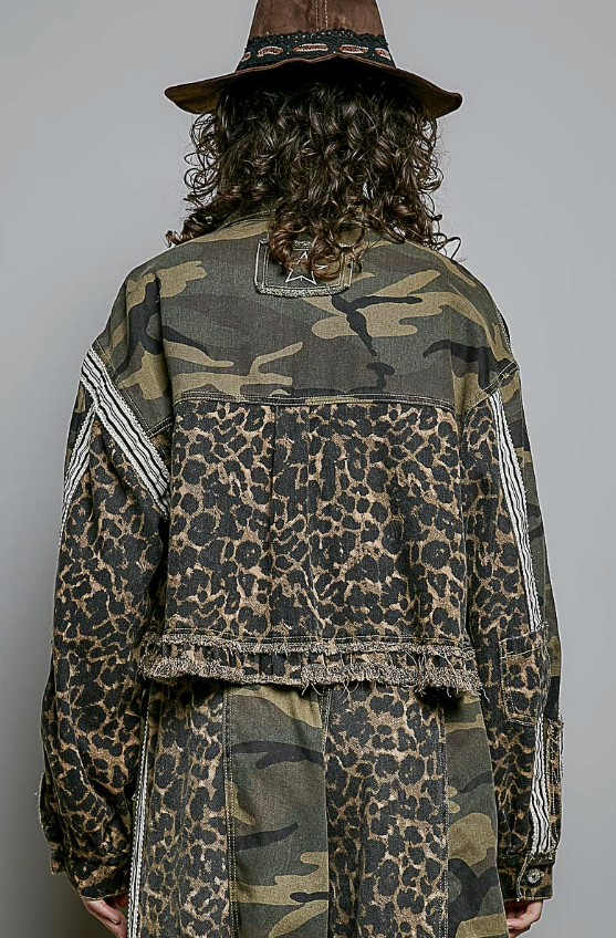 Back of woman modeling a camo and leopard jacket on solid grey background