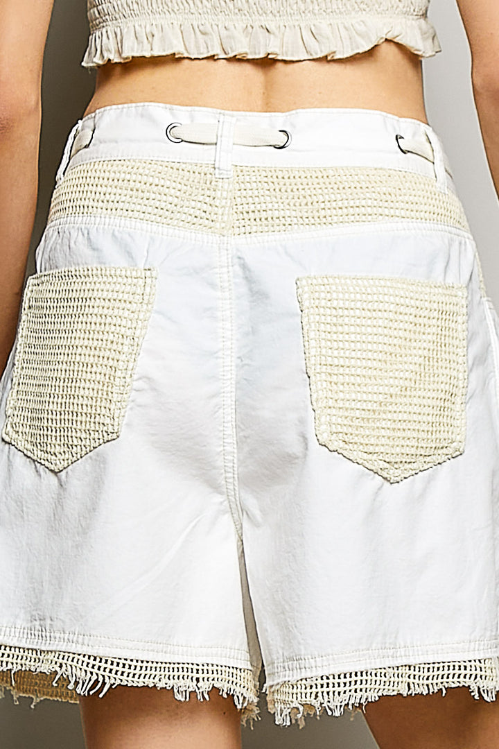 White denim shorts with textured pockets on a neutral background