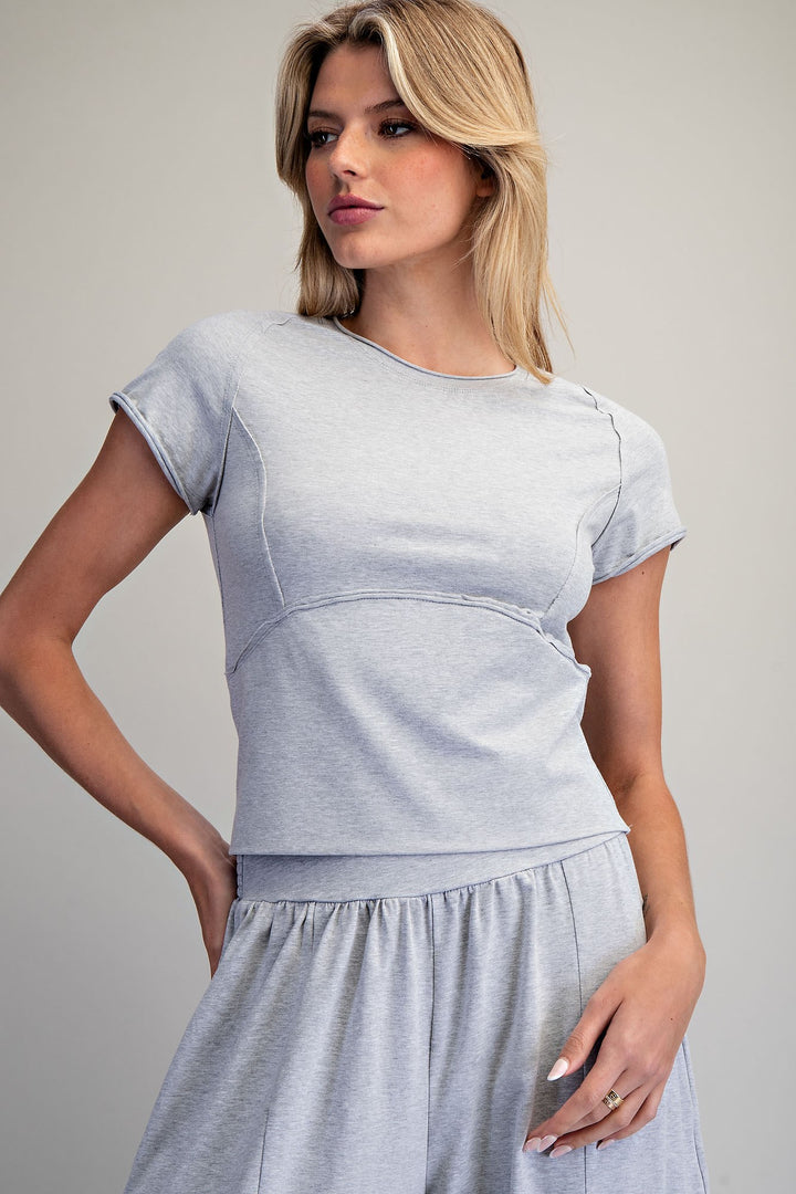 Woman wearing a light gray dress against a plain background