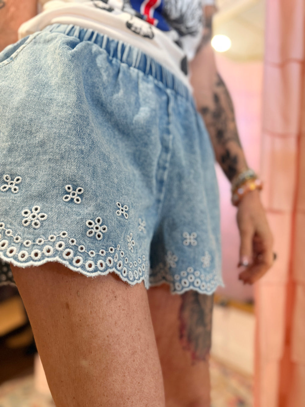 Denim shorts with floral embroidery on a blurred background