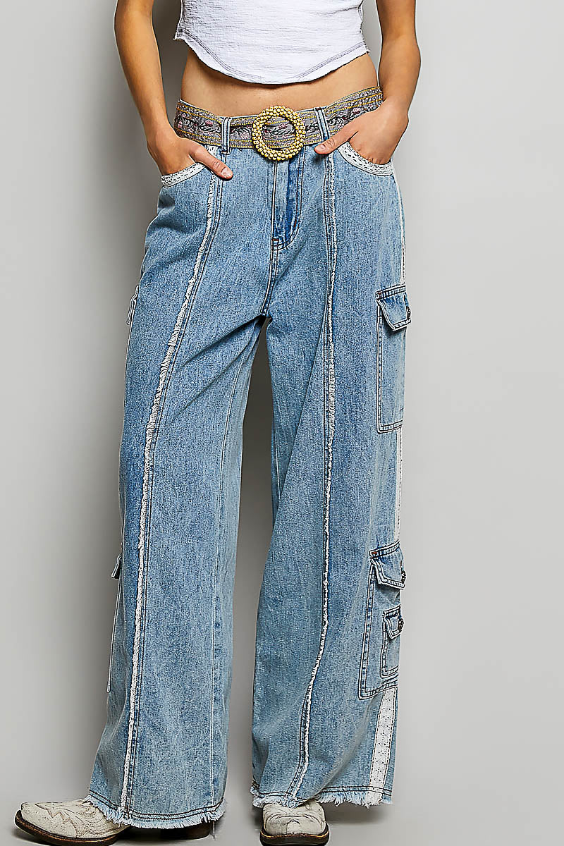 Person wearing wide-leg jeans with a belt on a plain background