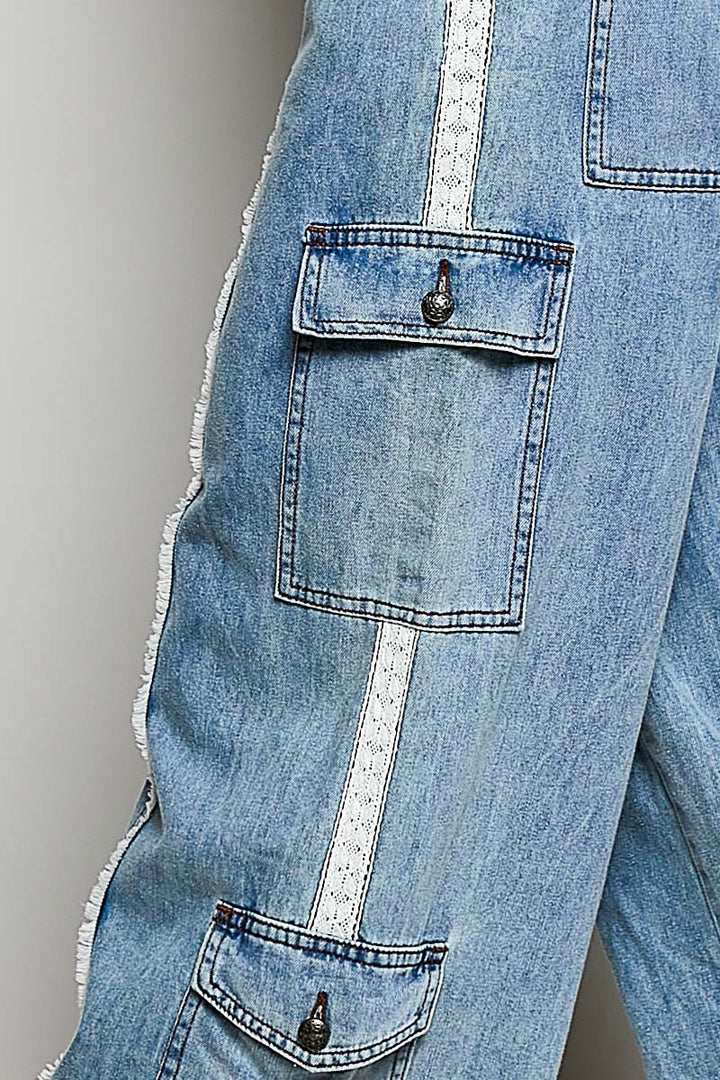 Close-up of light blue jeans with a pocket detail on a gray background