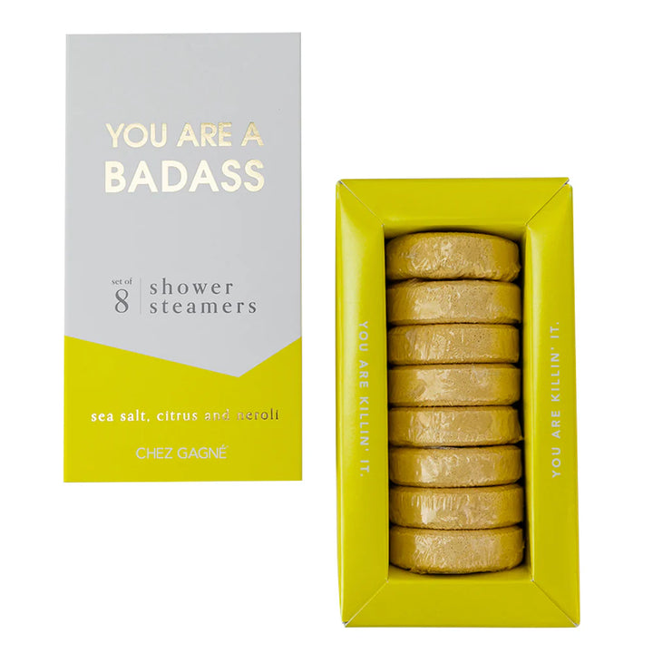 Chez Gagné shower steamers set in a bright yellow-green box next to its white and yellow packaging box, showing the wrapped round steamers inside.
