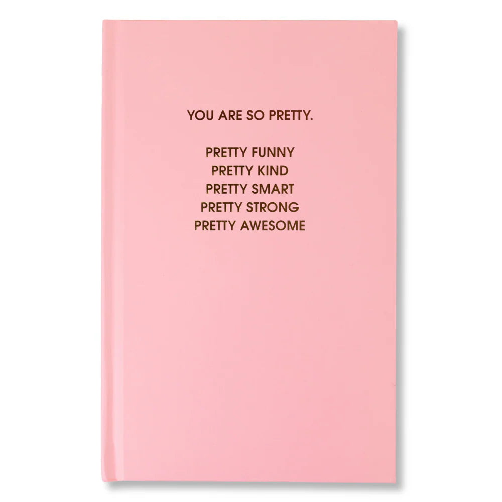 Pink notebook with motivational text on a white background