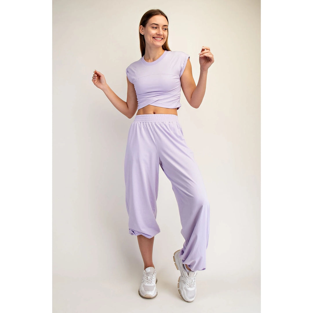 woman wearing matching purple set on plain background