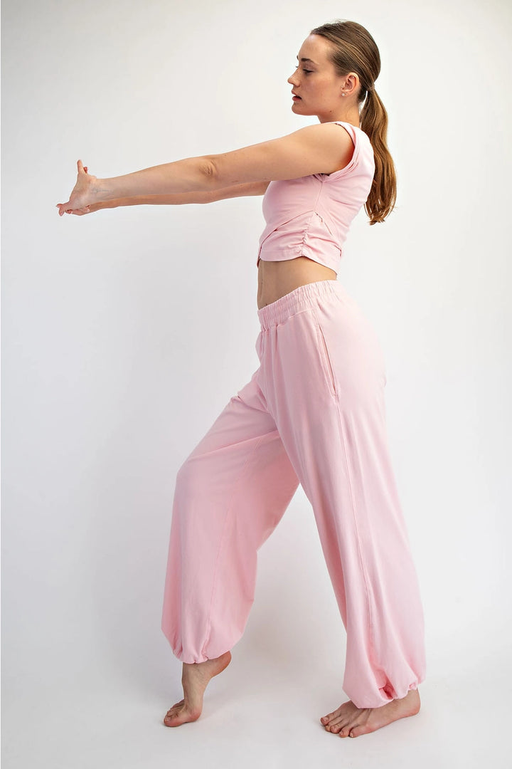 woman wearing matching pink set on plain background
