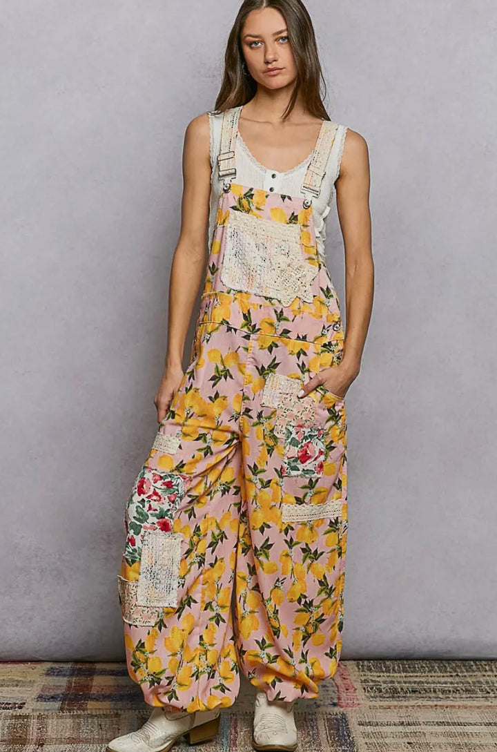 Woman wearing a floral jumpsuit against a plain background