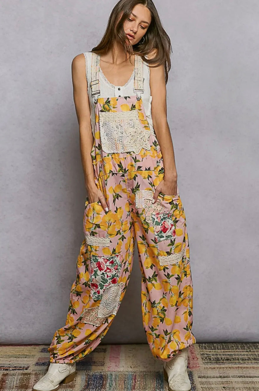 Woman wearing a floral overalls with a plain background