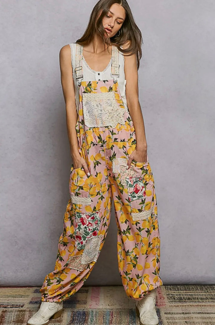 Woman wearing a floral overalls with a plain background