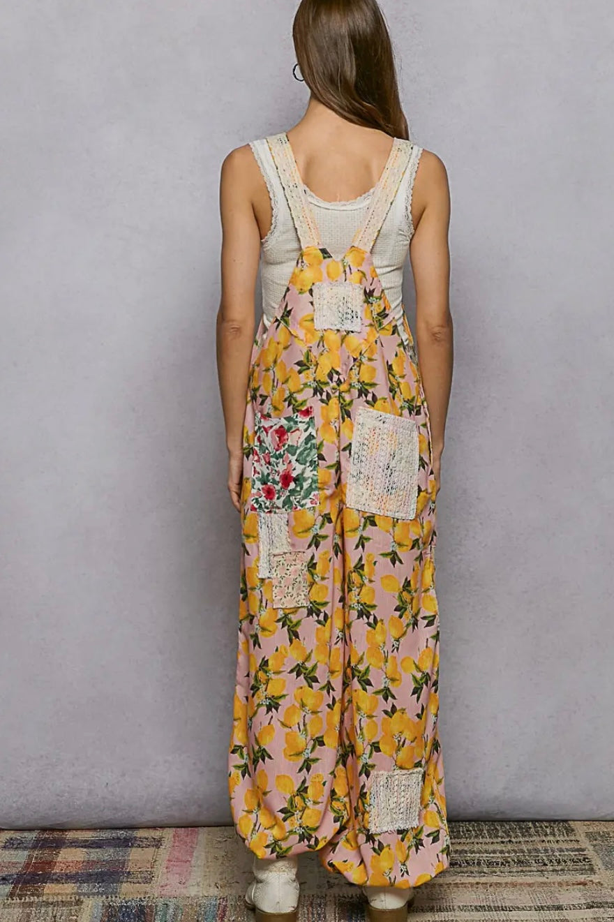 Woman wearing a floral overalls with a plain background