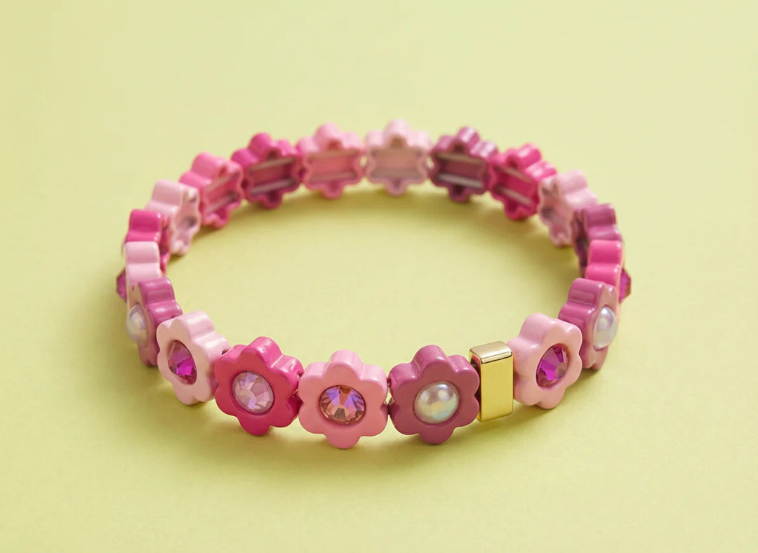 Pink beaded bracelet with flower-shaped beads on a light yellow background