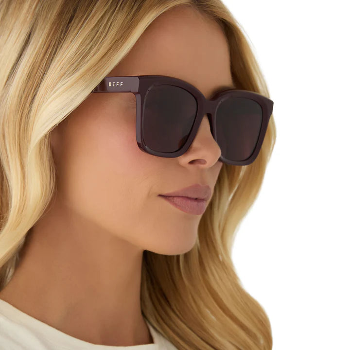 Woman wearing dark sunglasses with a blurred background