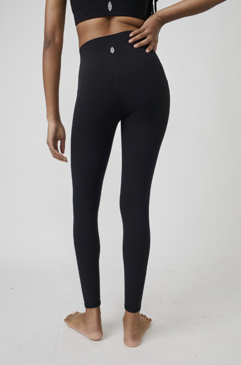 Person wearing black leggings on a plain background