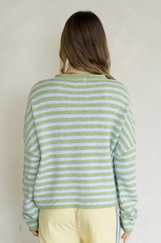 Woman wearing green stripe cardigan on plain background