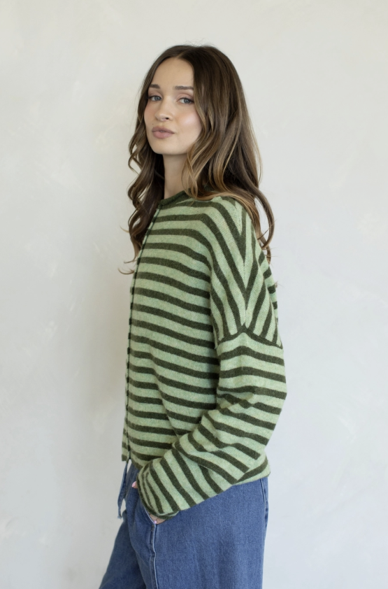 Woman wearing green stripe cardigan on plain background