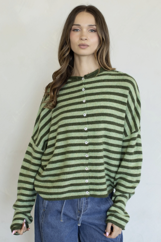 Woman wearing green stripe cardigan on plain background