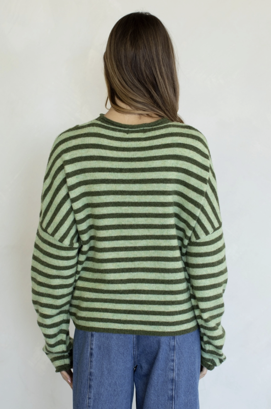 Woman wearing green stripe cardigan on plain background