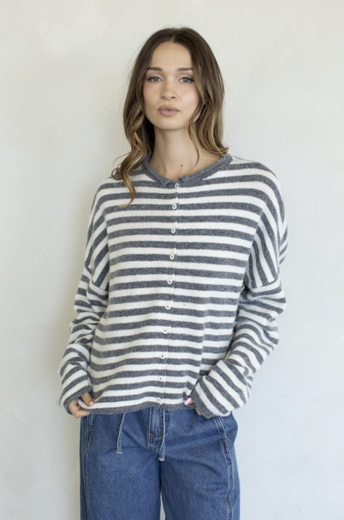 Woman wearing grey and ivory stripe cardigan on plain background
