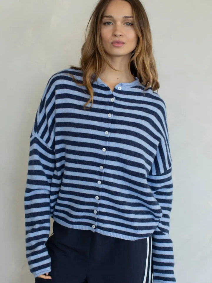 Woman wearing a blue and white striped sweater against a plain background
