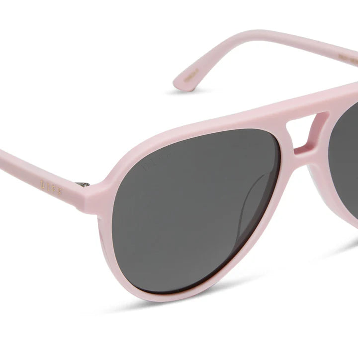 Pink sunglasses with dark lenses on a white background