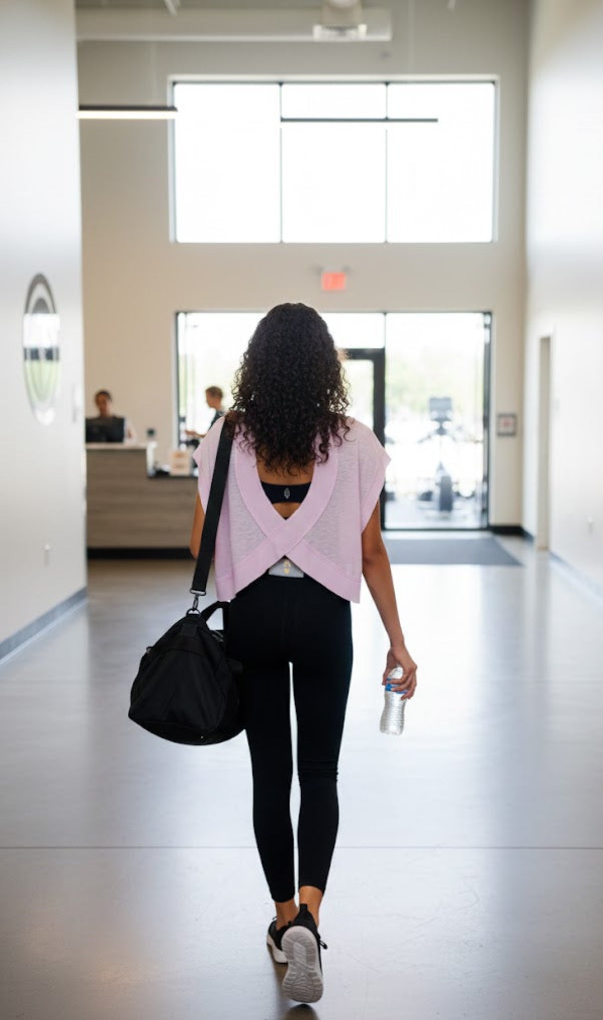 woman walking in gym with pink tshirt on