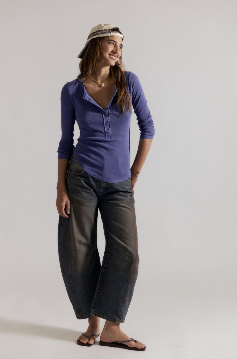 Woman wearing navy ribbed long sleeve top with black pants on white background